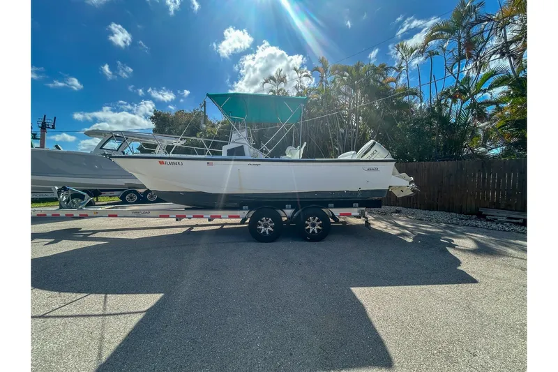 The Image of 1997 Boston Whaler 24 Outrage boat on trailer under sunny sky. - 1