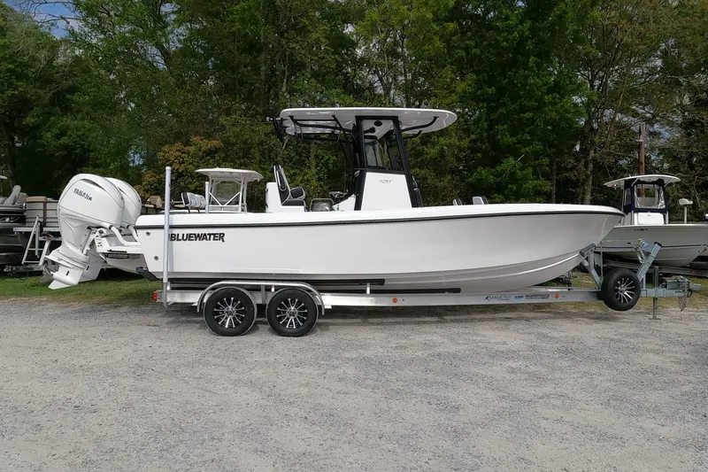 The Image of 2026 Bluewater Sportfishing 25T boat on trailer, parked outdoors with trees in background. - 1