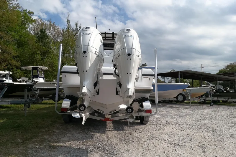 Slide: The Image of 2026 Bluewater Sportfishing 25T boat with dual engines on a trailer, parked outdoors. - 10