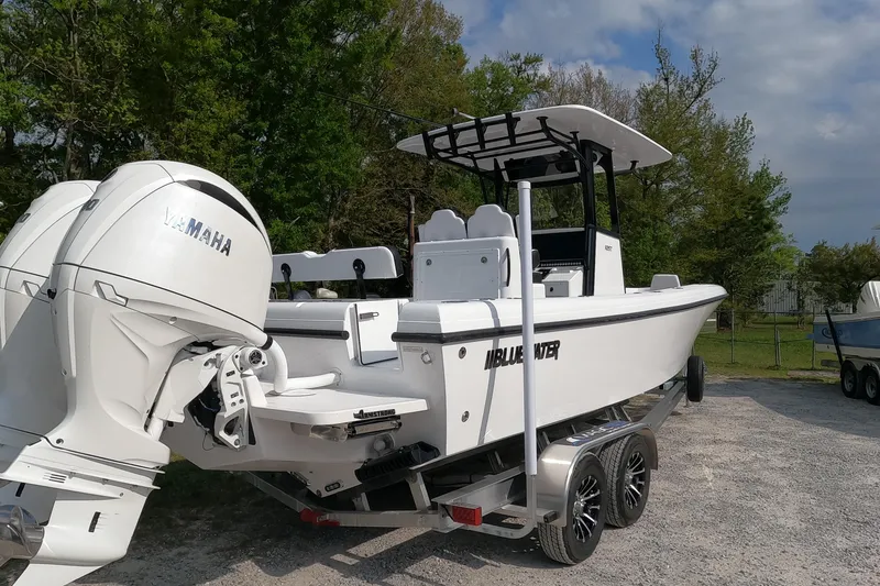 Slide: The Image of 2026 Bluewater Sportfishing 25T boat with Yamaha engines on a trailer, parked outdoors. - 11
