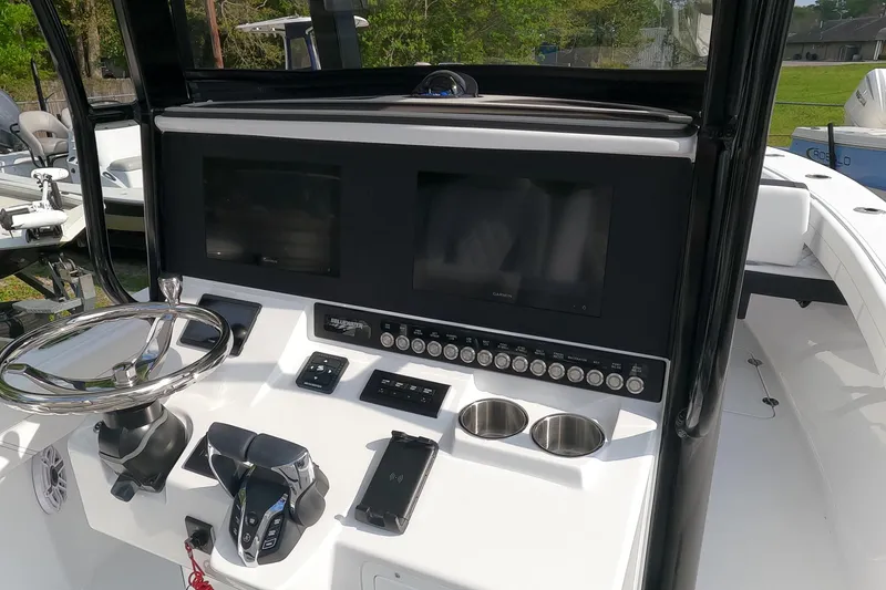 Slide: The Image of 2026 Bluewater Sportfishing 25T boat console with steering wheel and electronic displays. - 15