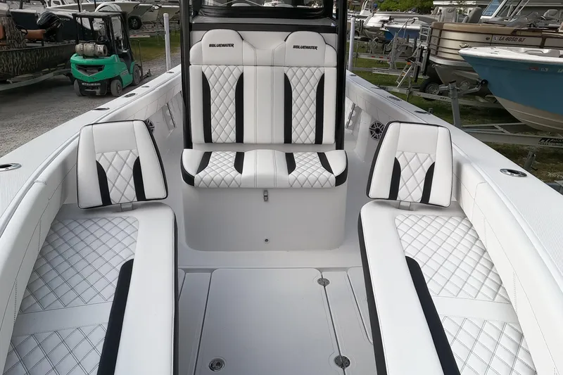 Slide: The Image of 2026 Bluewater Sportfishing 25T boat interior with white and black diamond-stitched seating. - 17