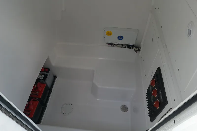 Slide: The Image of 2026 Bluewater Sportfishing 25T boat interior with battery storage and control panel. - 19