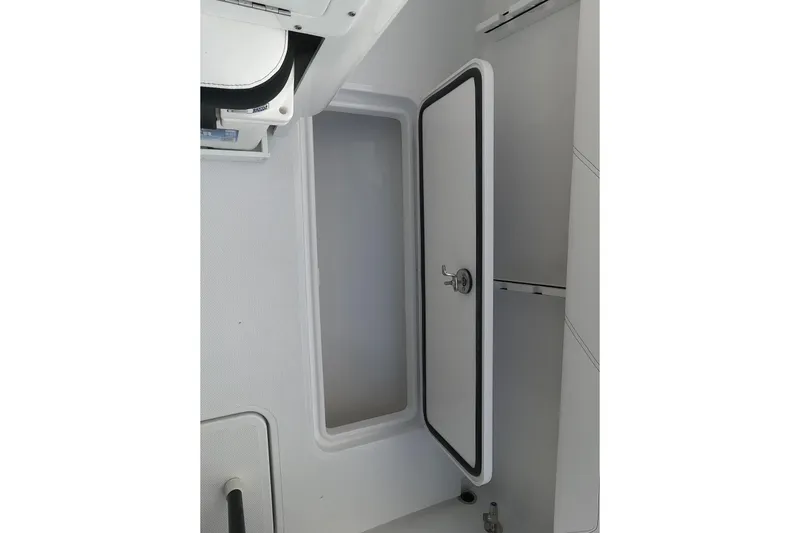 Slide: The Image of 2026 Bluewater Sportfishing 25T boat interior storage compartment with open hatch. - 21