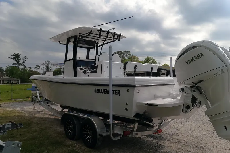 Slide: The Image of 2026 Bluewater Sportfishing 25T boat on trailer with Yamaha engine, parked outdoors. - 6