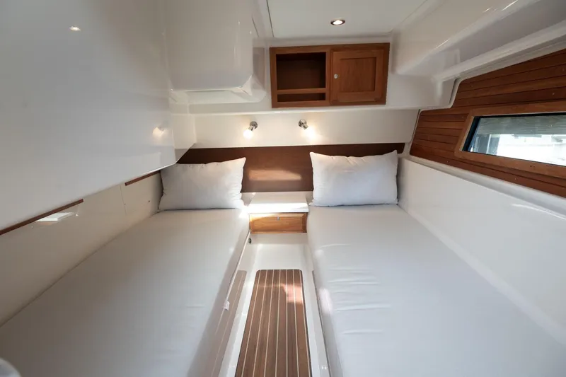 Slide: The Image of 2023 Back Cove 39O cabin interior with twin beds and wooden accents. - 18