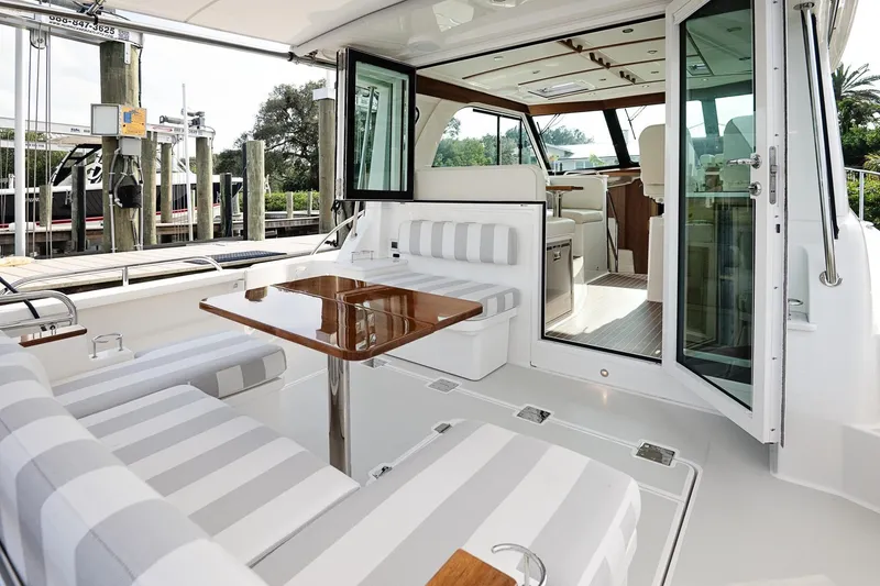 Slide: The Image of 2023 Back Cove 39O yacht with elegant interior and striped seating at a marina. - 35
