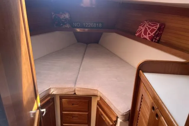 Slide: The Image of Wooden cabinetry inside a 1993 Catalina 36 MkII sailboat, featuring drawers and a louvered door. - 18