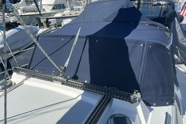 Slide: The Image of 1993 Catalina 36 MkII sailboat with blue canvas cover at marina. - 30