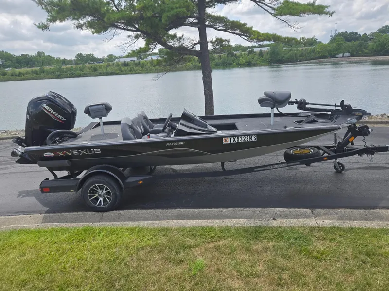Slide: The Image of 2022 Vexus AVX181 boat on trailer by a lake, featuring a Mercury outboard motor. - 11