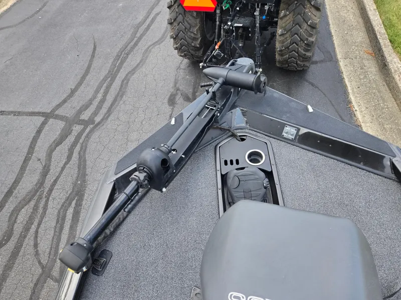 Slide: The Image of 2022 Vexus AVX181 boat with trolling motor, parked on asphalt near a tractor. - 17