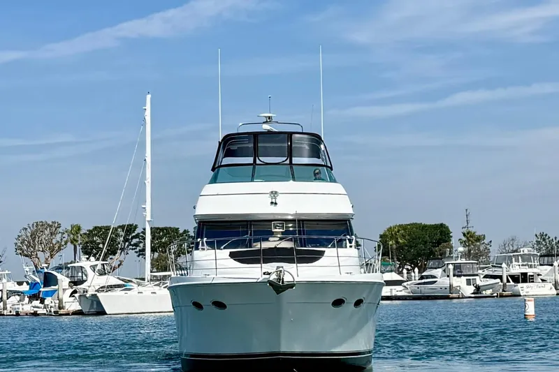 Slide: The Image of Front view of a 2000 Carver 53 Voyager yacht docked in a marina. - 1