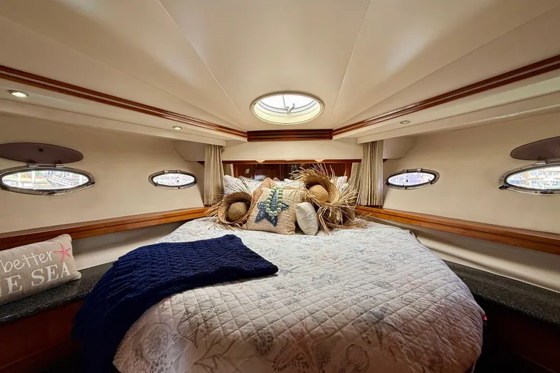 Slide: The Image of Luxurious bedroom interior of 2000 Carver 53 Voyager yacht with cozy bedding and porthole windows. - 11