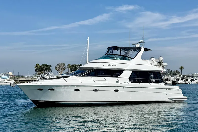 Slide: The Image of 2000 Carver 53 Voyager yacht on water, clear sky, marina background. - 2