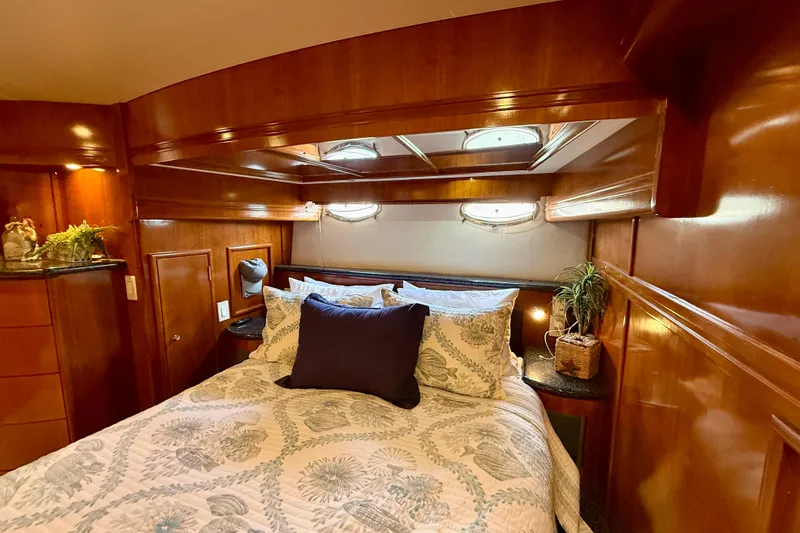 Slide: The Image of Luxurious bedroom interior of 2000 Carver 53 Voyager yacht with wood paneling and cozy bedding. - 49