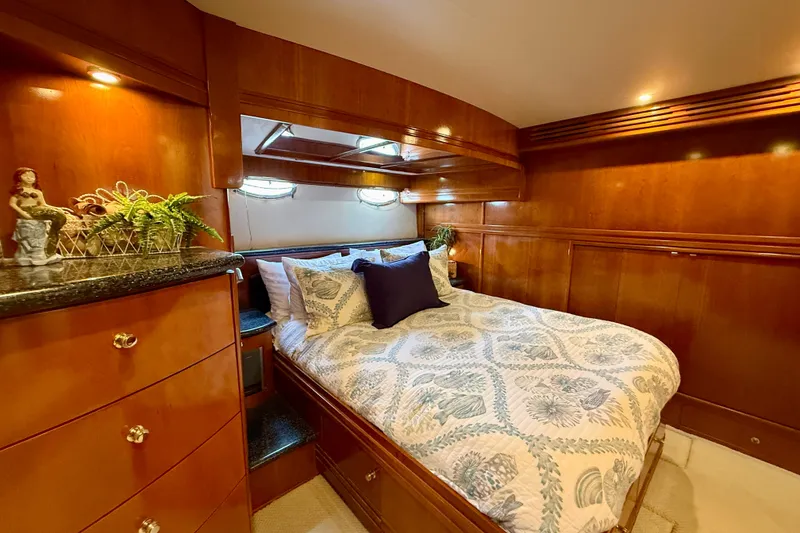 Slide: The Image of Luxurious bedroom interior of 2000 Carver 53 Voyager yacht with wood paneling and cozy bedding. - 52