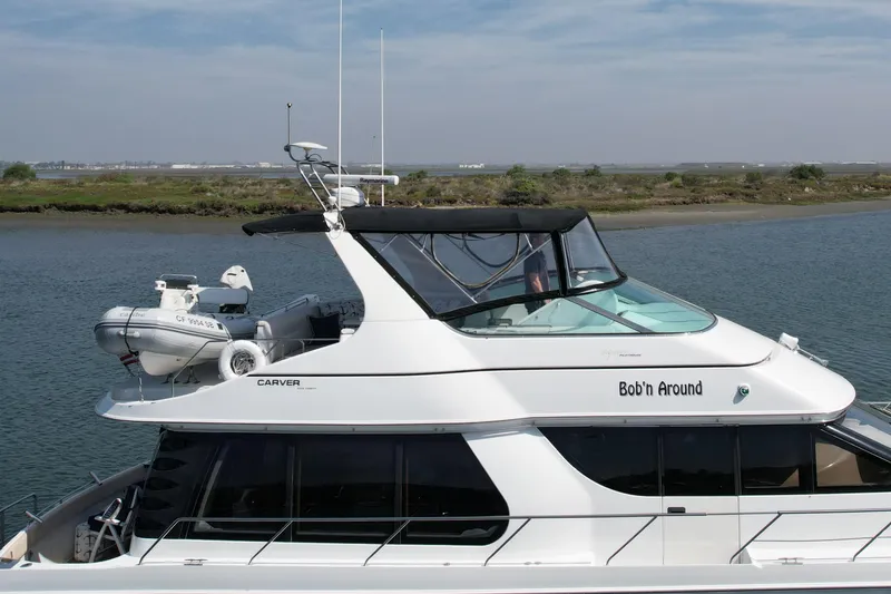 Slide: The Image of 2000 Carver 53 Voyager yacht named "Bob'n Around" on calm water. - 6