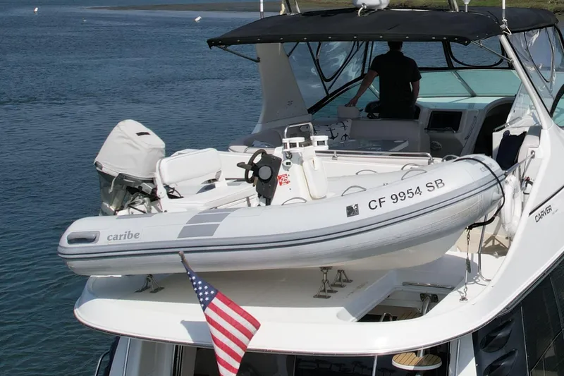 Slide: The Image of 2000 Carver 53 Voyager yacht with inflatable boat and American flag on deck. - 8