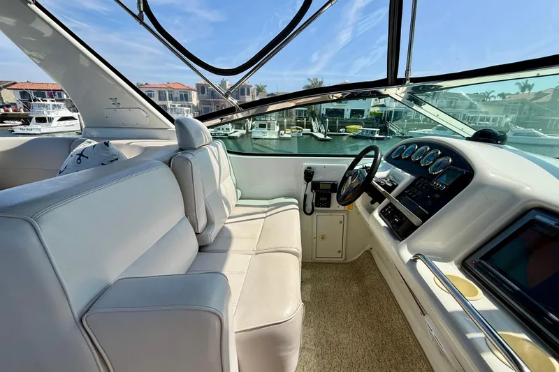 Slide: The Image of Interior view of a 2000 Carver 53 Voyager yacht cockpit with plush seating and control panel. - 83