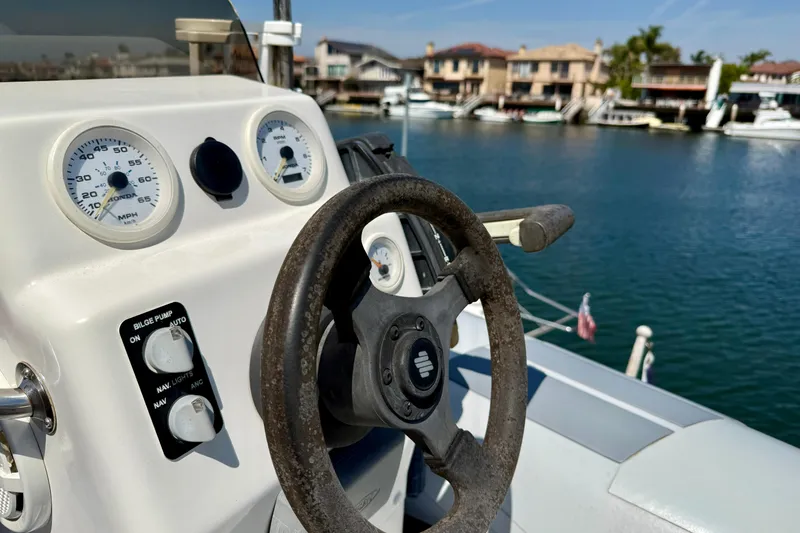Slide: The Image of Steering wheel and dashboard of a 2000 Carver 53 Voyager yacht, overlooking a marina. - 92