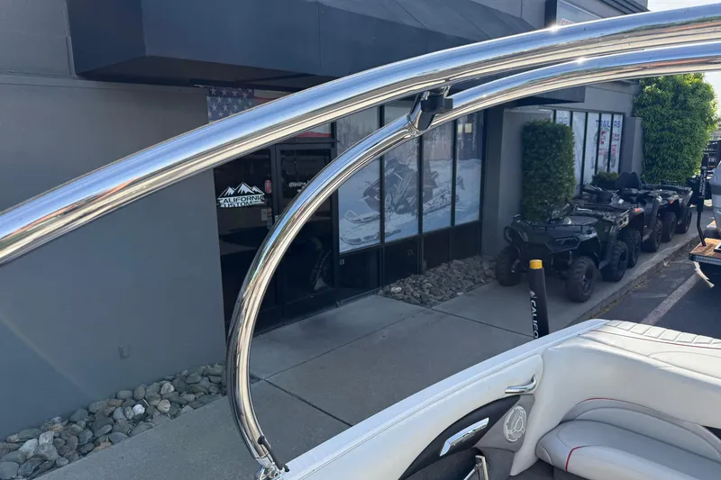 Slide: The Image of 2009 Malibu Response LXi boat with chrome details near a showroom and parked ATVs. - 24