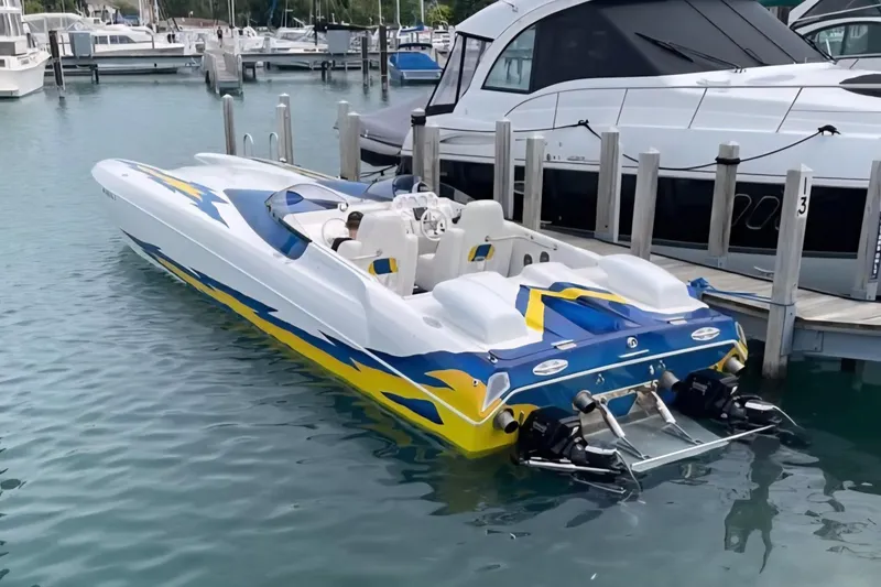 Slide: The Image of 2001 Eliminator 36 Daytona speedboat docked in marina, featuring vibrant blue and yellow design. - 4