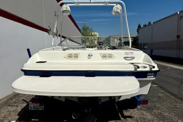 Slide: The Image of 2006 Bayliner 205 boat, rear view, parked outdoors near buildings. - 12