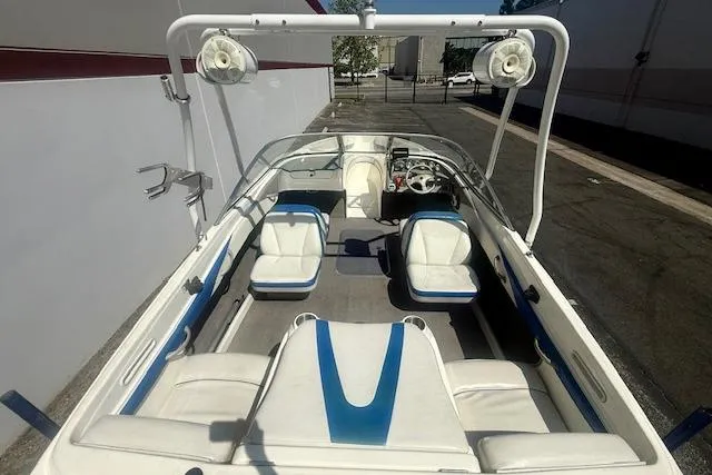 Slide: The Image of 2006 Bayliner 205 boat interior with white and blue seating, featuring a sleek design. - 14