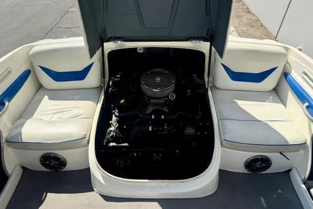 Slide: The Image of 2006 Bayliner 205 boat engine compartment with open cover, showcasing interior seating and speakers. - 15