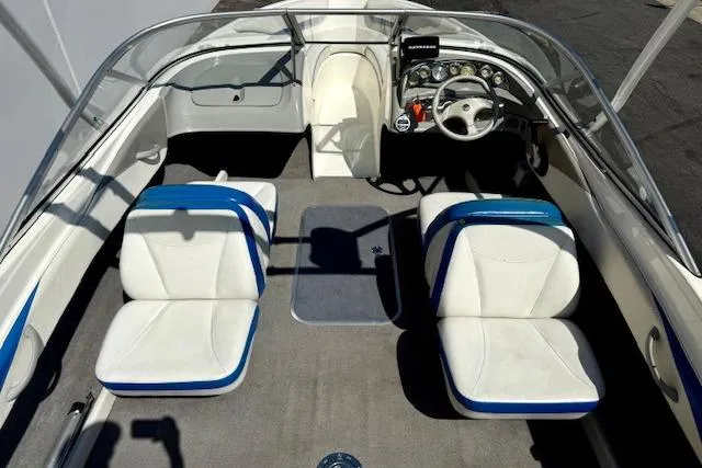 Slide: The Image of Interior of a 2006 Bayliner 205 boat with white and blue seating. - 19