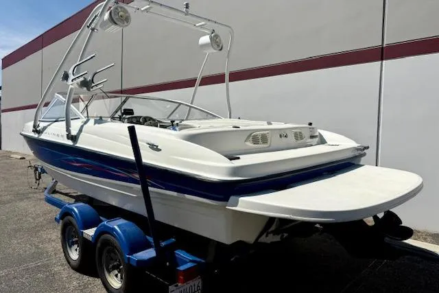 Slide: The Image of 2006 Bayliner 205 boat on trailer, featuring a sleek design and wakeboard tower. - 2