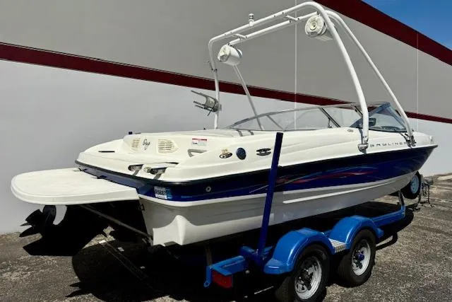 Slide: The Image of 2006 Bayliner 205 boat on trailer, featuring sleek design and white hull with blue accents. - 3