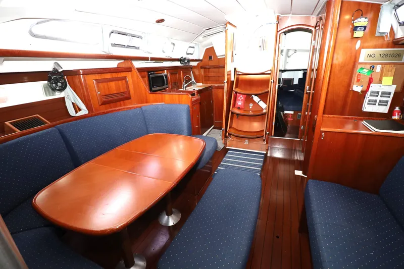 Slide: The Image of Interior of 2005 Beneteau Oceanis Clipper 423 yacht with wooden furnishings and blue seating. - 10