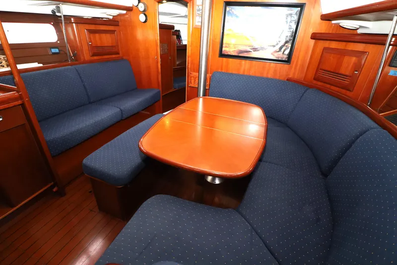 Slide: The Image of Interior of 2005 Beneteau Oceanis Clipper 423 yacht with blue seating and wooden table. - 11