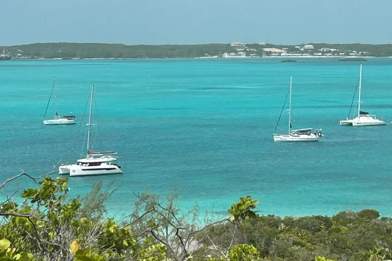 Slide: The Image of Sailboats, including a 2005 Beneteau Oceanis Clipper 423, anchored in turquoise waters. - 14