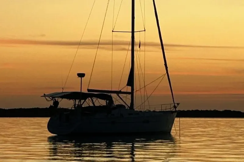 Slide: The Image of Sailboat silhouette at sunset, 2005 Beneteau Oceanis Clipper 423 on calm water. - 16