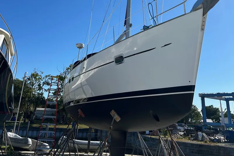 Slide: The Image of 2005 Beneteau Oceanis Clipper 423 sailboat on dry dock under clear blue sky. - 17