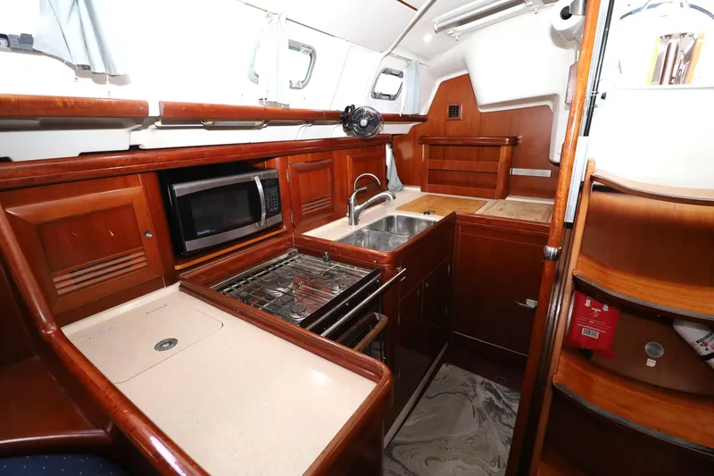 Slide: The Image of Galley kitchen in 2005 Beneteau Oceanis Clipper 423 yacht with wood cabinetry. - 2