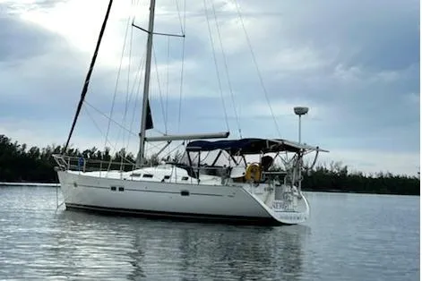 Slide: The Image of 2005 Beneteau Oceanis Clipper 423 sailboat anchored on calm water under cloudy sky. - 22