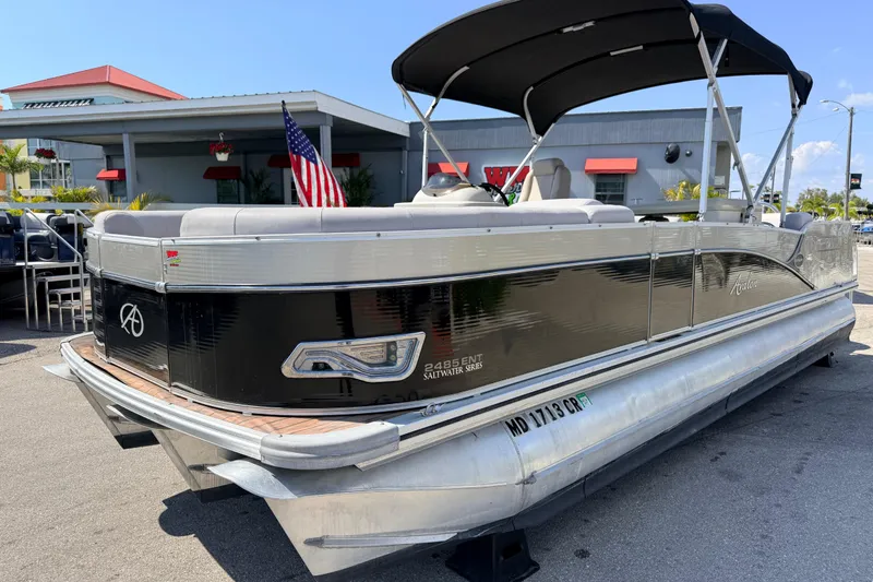 The Image of 2014 Avalon 2485 Catalina Entertainer Tri Toon boat with canopy, parked outdoors. - 1