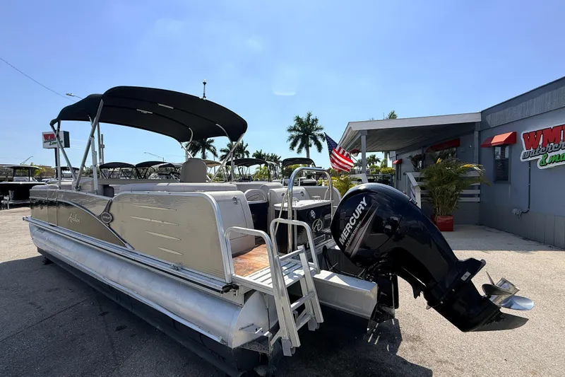 Slide: The Image of 2014 Avalon 2485 Catalina Entertainer Tri Toon boat with Mercury engine, docked outdoors. - 10