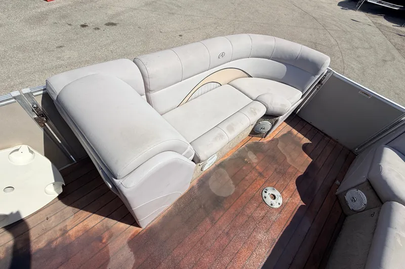 Slide: The Image of 2014 Avalon 2485 Catalina Entertainer boat interior with curved seating and wooden deck. - 15