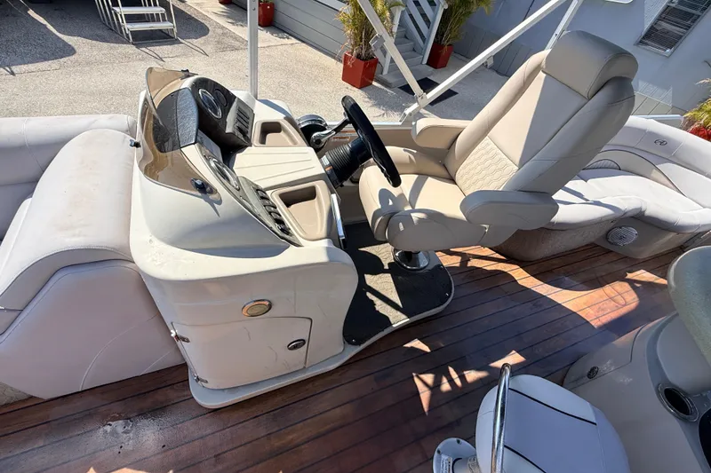 Slide: The Image of 2014 Avalon 2485 Catalina Entertainer boat interior with helm and seating on wooden deck. - 19