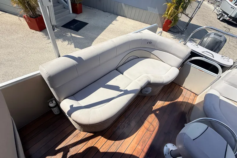 Slide: The Image of 2014 Avalon 2485 Catalina Entertainer boat interior with plush seating and wooden deck. - 21