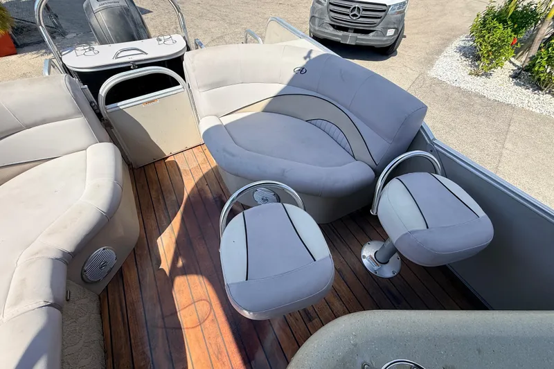 Slide: The Image of 2014 Avalon 2485 Catalina Entertainer boat interior with plush seating and wooden deck. - 22