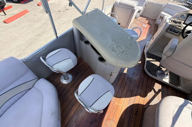 Slide: The Image of 2014 Avalon 2485 Catalina Entertainer boat interior with bar and seating on wooden deck. - 24