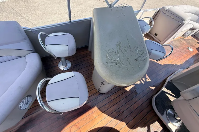 Slide: The Image of 2014 Avalon 2485 Catalina Entertainer boat interior with bar and seating on wooden deck. - 25