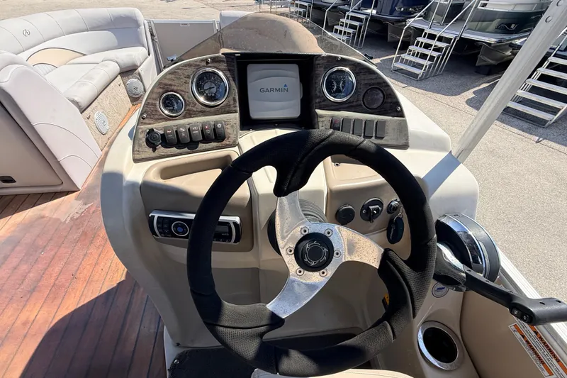 Slide: The Image of 2014 Avalon 2485 Catalina Entertainer boat dashboard with steering wheel and Garmin display. - 28