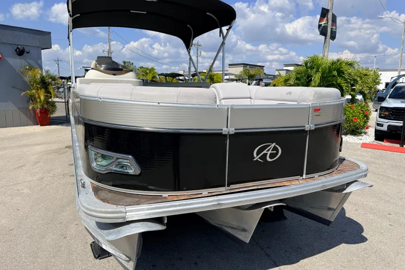 Slide: The Image of 2014 Avalon 2485 Catalina Entertainer Tri Toon boat with black exterior, parked outdoors. - 4