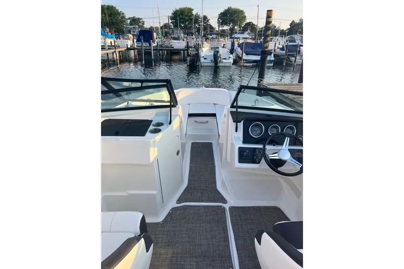 Slide: The Image of 2020 Sea Ray SPX 210 boat interior with steering wheel and dashboard, docked at marina. - 17